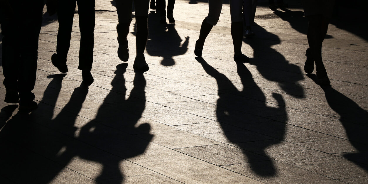 Black silhouettes and shadows of people on the street