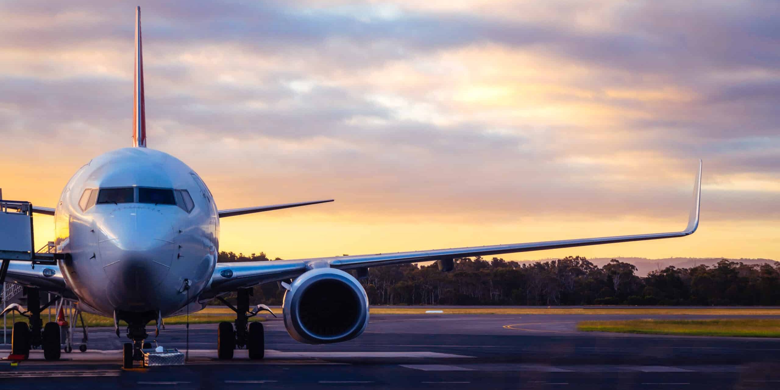 Sunset view of airplane on airport runway under dramatic sky in Hobart,Tasmania, Australia. Aviation technology and world travel concept.